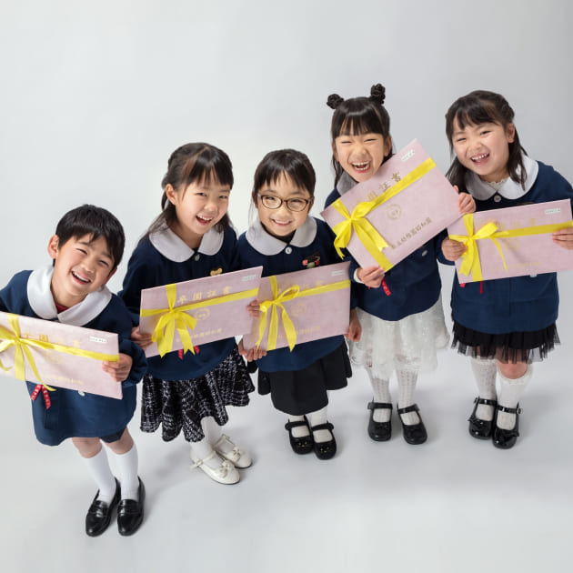 卒業入学撮影　グループで卒園証書持って笑顔の男女