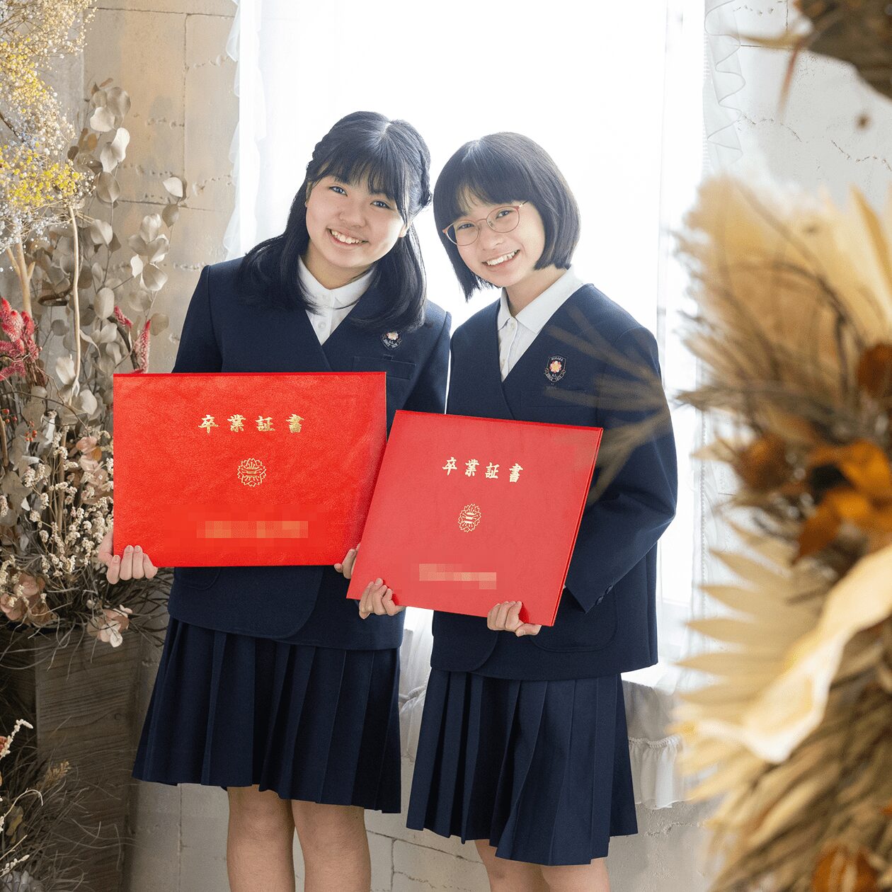 卒業証書を持った2人の児童