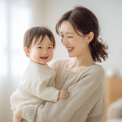 笑顔の赤ちゃんを抱っこして微笑んでいる母親